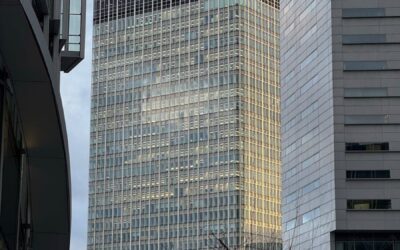 A towering skyscraper in Paris's La Défense district captured from the ground level.