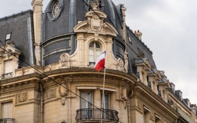 Elegant architectural detail of Banque de France building in Orléans with French flag.