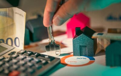 hand holding key over house models