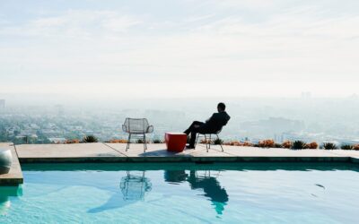 a person sitting in a chair by a pool