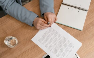 Hands reviewing documents on a wooden desk, ideal for business themes.