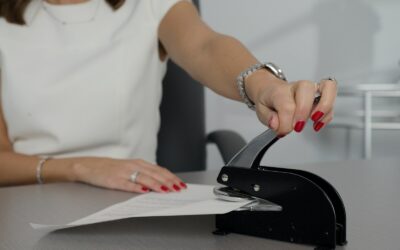 woman in white shirt holding pen writing on white paper