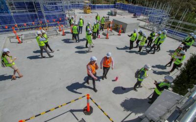 a group of construction workers standing on top of a building