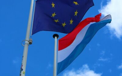 Flags of the eu and luxembourg wave in the sky