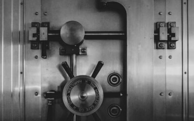 A heavy steel bank vault door with a large circular locking wheel