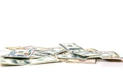 a pile of money sitting on top of a white table