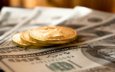 three round gold-colored coins on 100 US dollar banknotes
