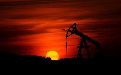 oil pump jack silhouette against red sunset