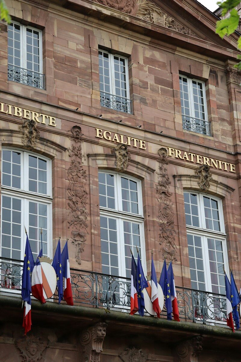 Stone building with french flags and motto