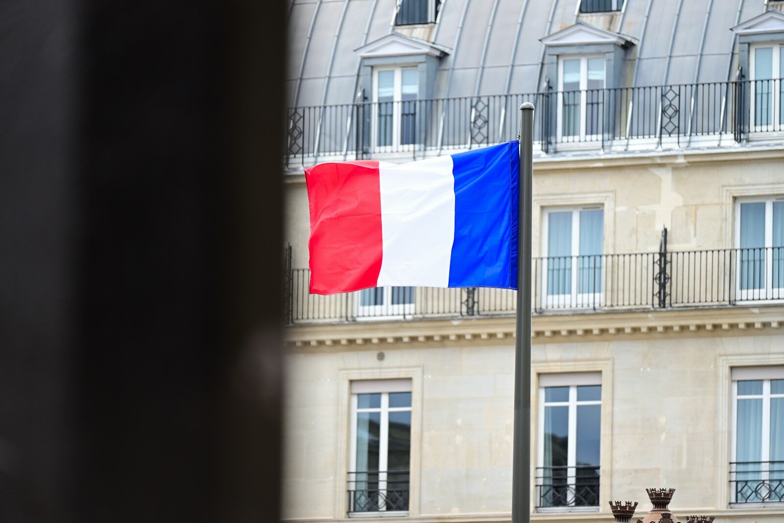A flag flying in front of a tall building
