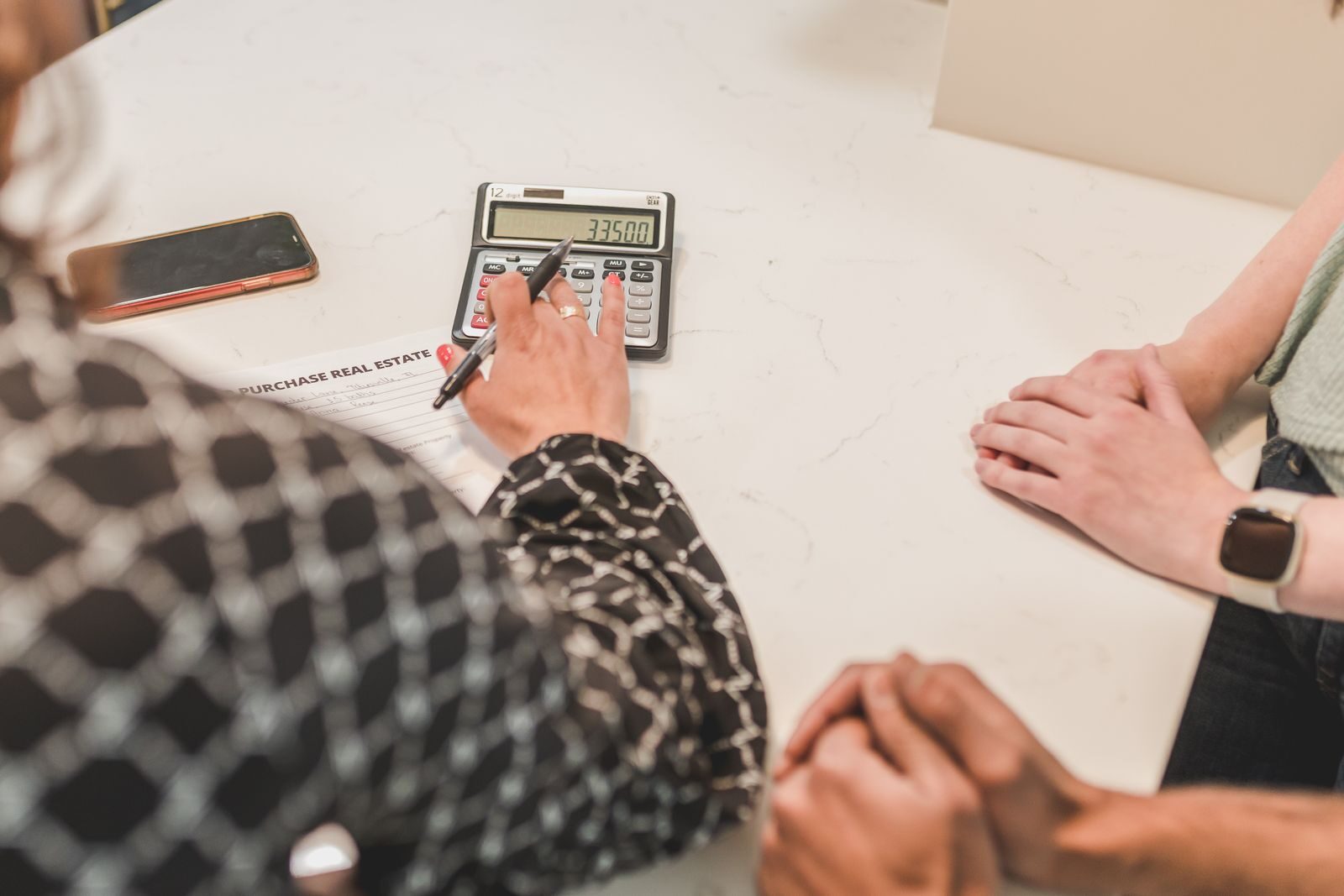 Calculatrice et dossier de prêt sur un bureau pour estimer sa capacité d’emprunt avant un achat immobilier