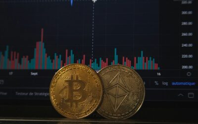 Écran de cotations affichant le graphique du cycle du bitcoin, avec une pièce physique au premier plan