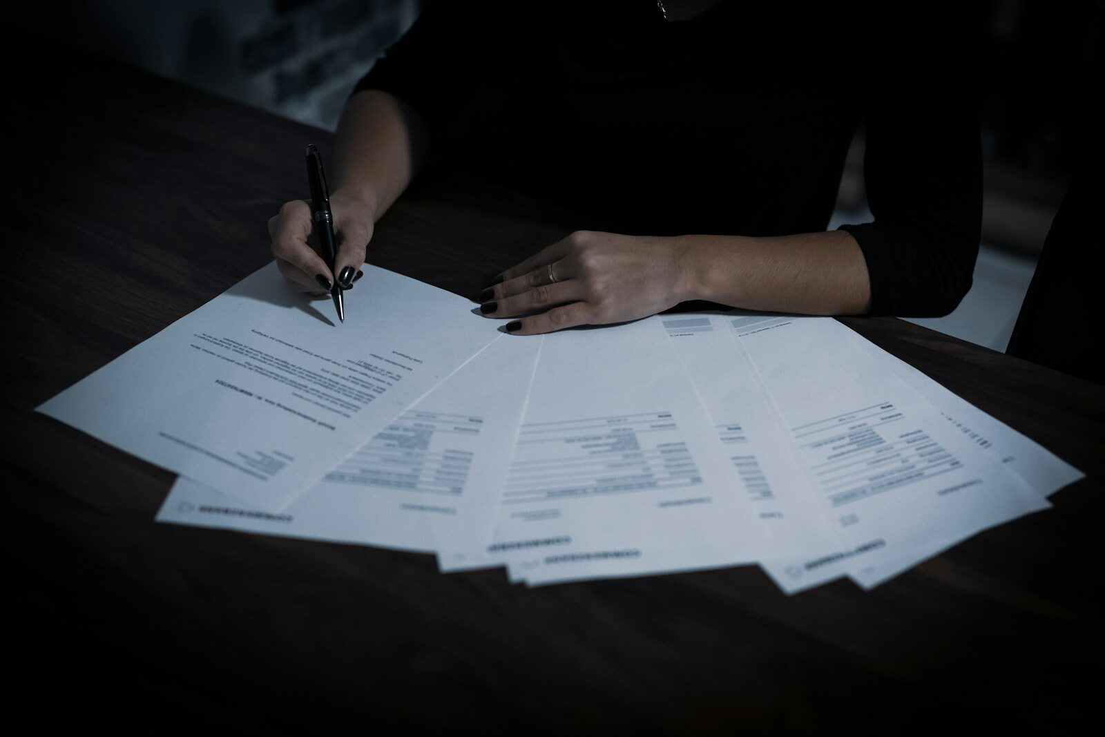Propriétaire relisant les documents de son appartement avant de revendre à perte un bien acheté en 2021