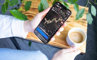 Jeune femme consultant une application de Bourse sur son téléphone, parmi les nouveaux investisseurs
