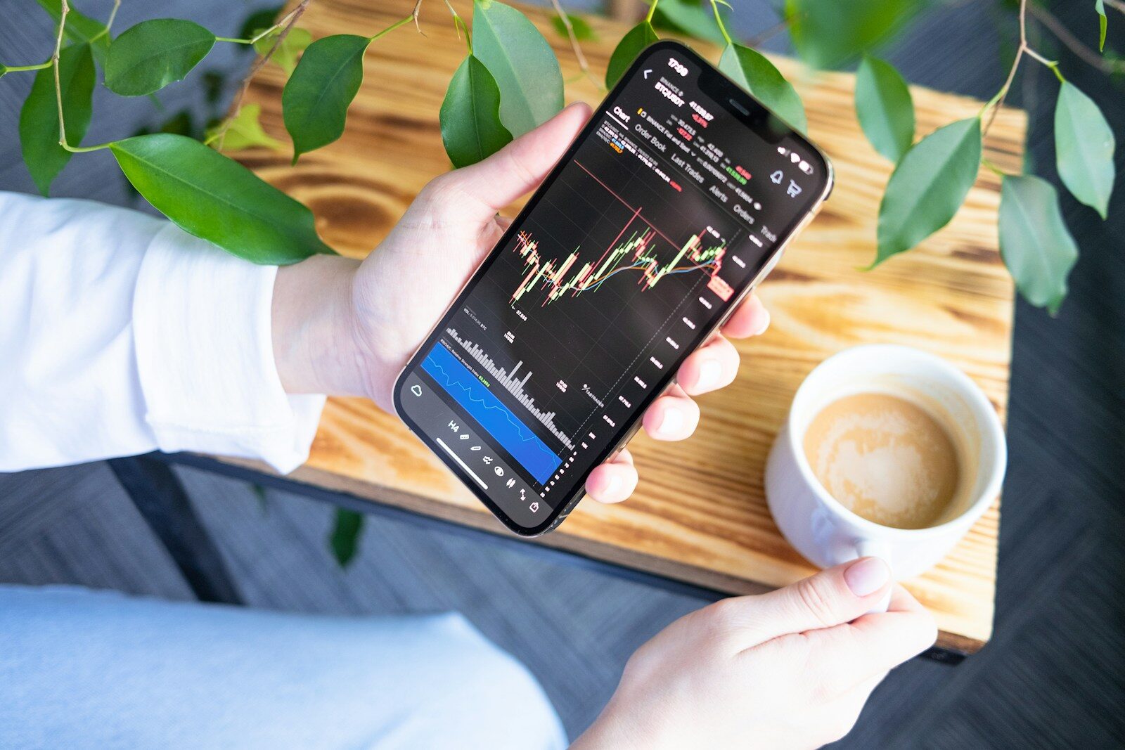 Jeune femme consultant une application de Bourse sur son téléphone, parmi les nouveaux investisseurs